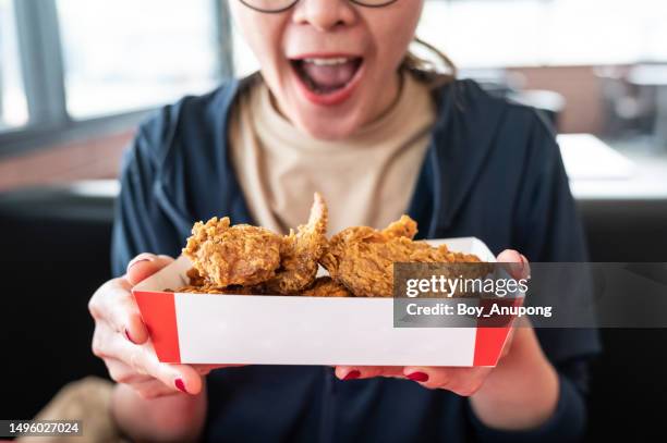 happiness woman holding a paper box with pieces of fried chicken before eating. - fried chicken fotografías e imágenes de stock