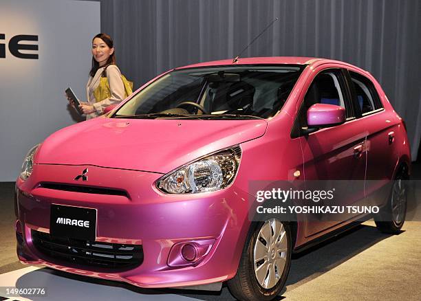 Model poses next to Japan's car manufacturer Mitsubishi Motors new global compact car "Mirage" in Tokyo on August 1, 2012. The Mirage, which is...