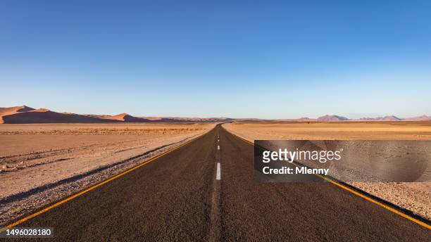offene wüstenstraße durch die sossusvlei wüste in namibia - wüstenstraße stock-fotos und bilder