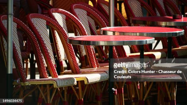 bistro-style chairs and tables on the sunny terrace of a restaurant in paris, france - bar paris stock pictures, royalty-free photos & images