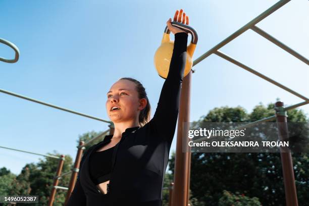 young adult athlete of kettlebell sport doing workout on outdoors workout area - kettlebell stock pictures, royalty-free photos & images