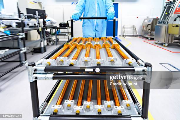 group of magnetorquer rods coils for cubesat satellites pushed blurred motion on an anti-static trolley in cleanroom - clean suit stock pictures, royalty-free photos & images