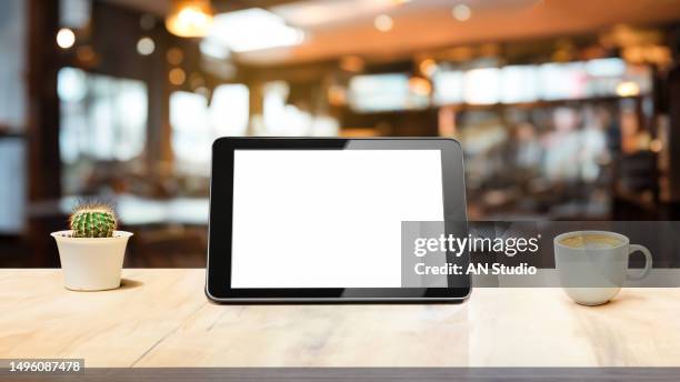digital tablet blank screen on table in cafe background. digital tablet with blank screen on table of coffee shop blur background - graphics tablet stock pictures, royalty-free photos & images