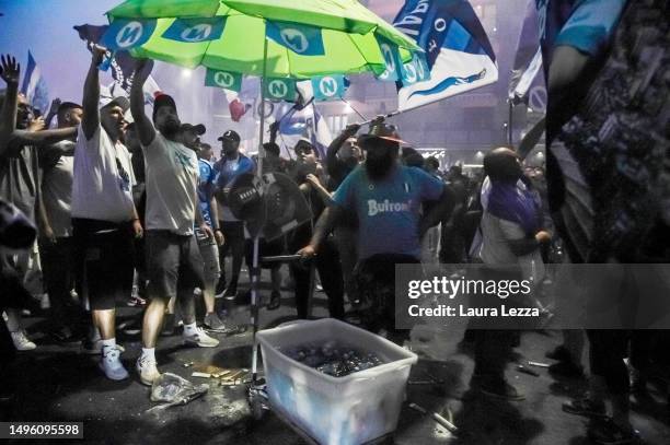 Beverage seller stands among Napoli fans celebrating the victory of the Italian Championship and the Scudetto in front of the Maradona Stadium on...