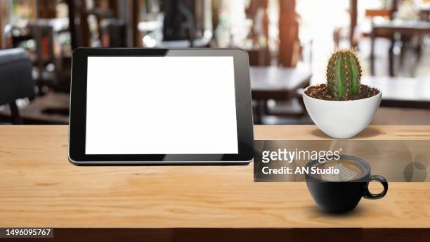 digital tablet blank screen on table in cafe background. digital tablet with blank screen on table of coffee shop blur background - coffee table front view stock pictures, royalty-free photos & images