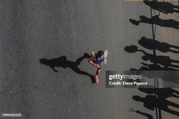 unknown male triathlete running fast marathon distance and greeting fans, high angle view, abstract sports background - male feet - fotografias e filmes do acervo