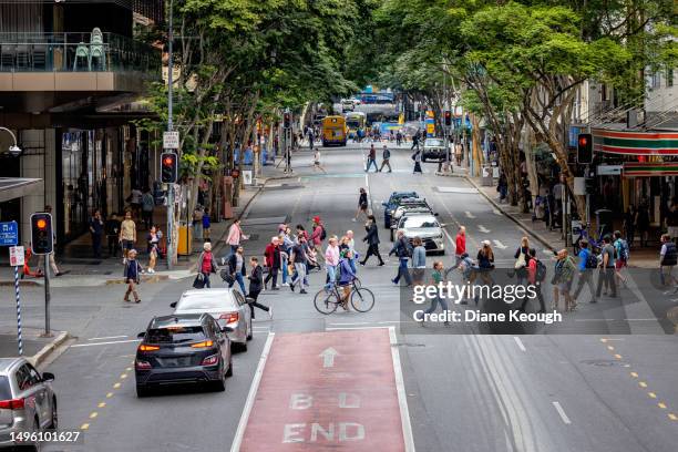 pedestrians cross a busy intersection in the city - pedestrian stock pictures, royalty-free photos & images