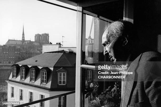 Le photographe hongrois André Kertész à la fenêtre d'un appartement à Paris, circa 1970, France.