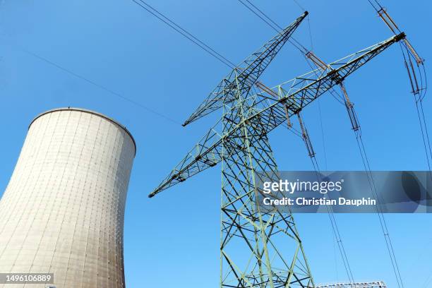 electricity pylon and cooling toweron a clear blue sky. - poteau d'appui stock pictures, royalty-free photos & images