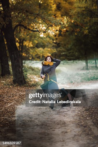 Embracing spirit of fall: radiant plus-size woman in coat and hat shares laughter and fun with her black poodle dog, creating lasting memories in serene backdrop of an autumn park Embracing spirit of fall: radiant plus-size woman in coat and hat shares laughter and fun with her black poodle dog, creating lasting memories in serene backdrop of an autumn park
