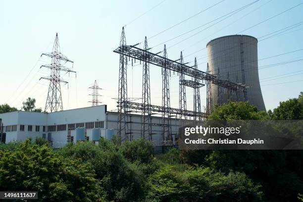 electricity pylon and cooling toweron a clear blue sky. - poteau d'appui stockfoto's en -beelden