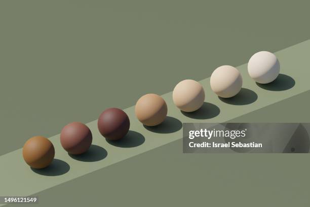 spheres arranged in line in different skin tones. - igualdad fotografías e imágenes de stock