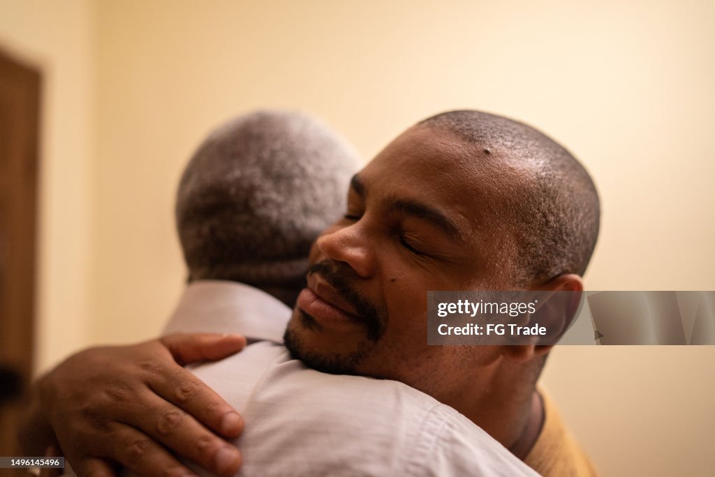 Bonding moment of father and son embracing and giving emotional support at home