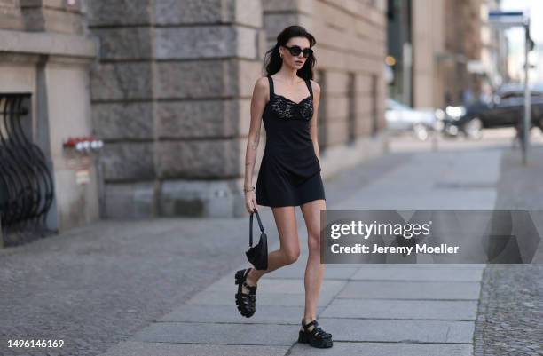 Celine Bethmann wears Celine black shades, Prada triangle black leather bag, Prada black rubber sandals, House of CB black mini dress on June 05,...