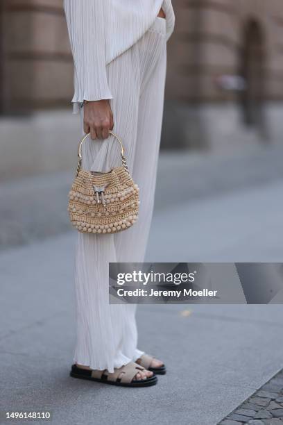 Celine Bethmann wears Hermes Chypre brown velvet leather sandals, ninety9 matching white linen flannel and wide pants and Jimmy Choo mini raffia bast...