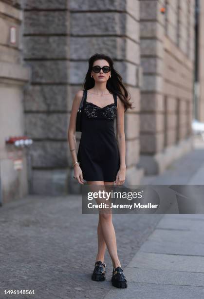 Celine Bethmann wears Celine black shades, Prada triangle black leather bag, Prada black rubber sandals, House of CB black mini dress on June 05,...