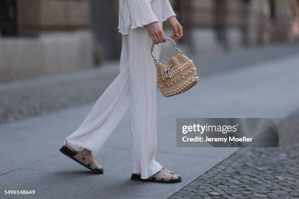 Celine Bethmann wears Hermes Chypre brown velvet leather sandals, ninety9 matching white linen flannel and wide pants and Jimmy Choo mini raffia bast...