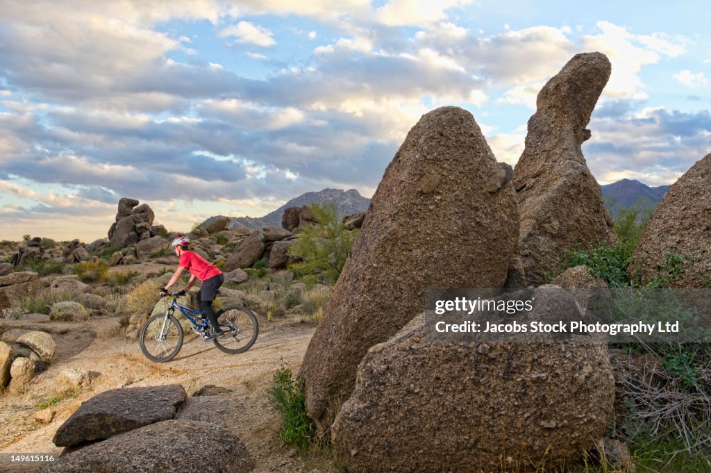 Caucasian man riding mountain bike in remote area