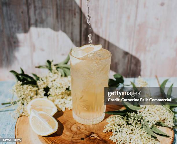 a fresh cold lemon lemon drink on a wooden chopping board - drinking lemonade stock pictures, royalty-free photos & images