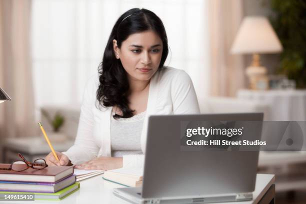 mixed race woman studying on laptop - elearning stock-fotos und bilder