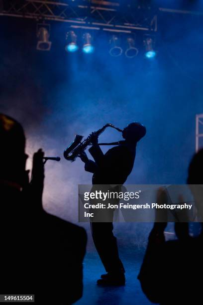 black musician playing saxophone on stage - blues music stock-fotos und bilder