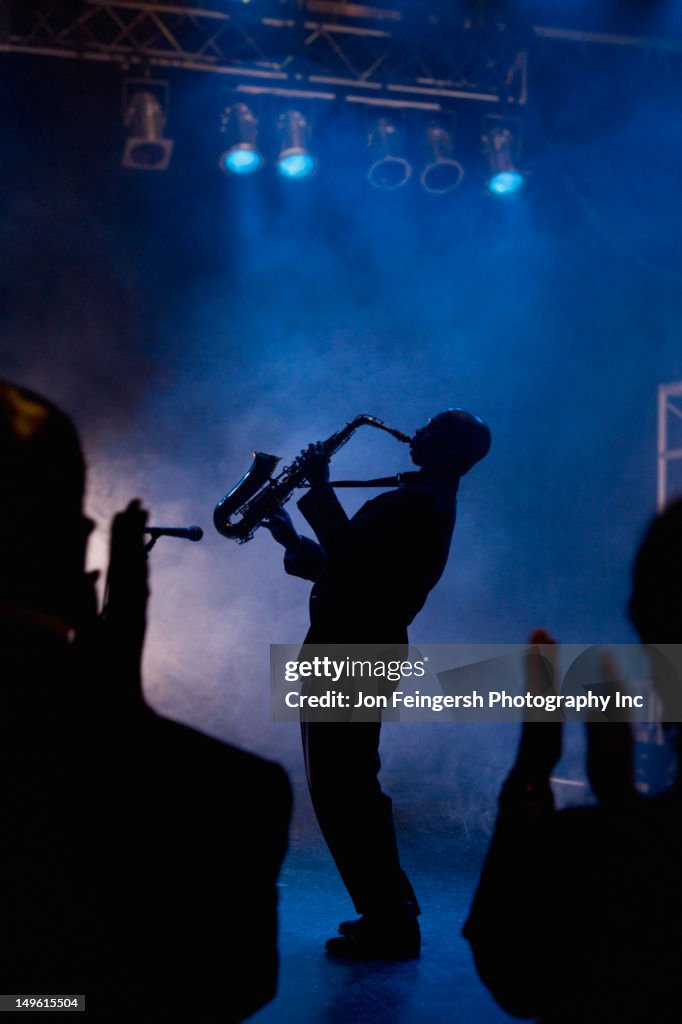 Black musician playing saxophone on stage