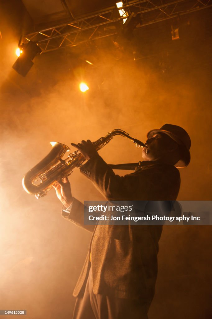 Black musician playing saxophone on stage