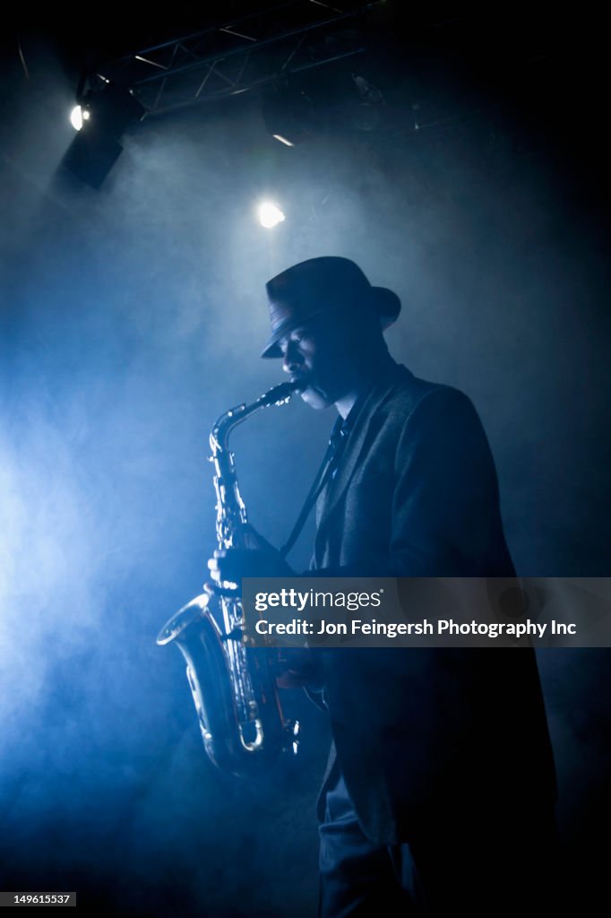 Black musician playing saxophone on stage