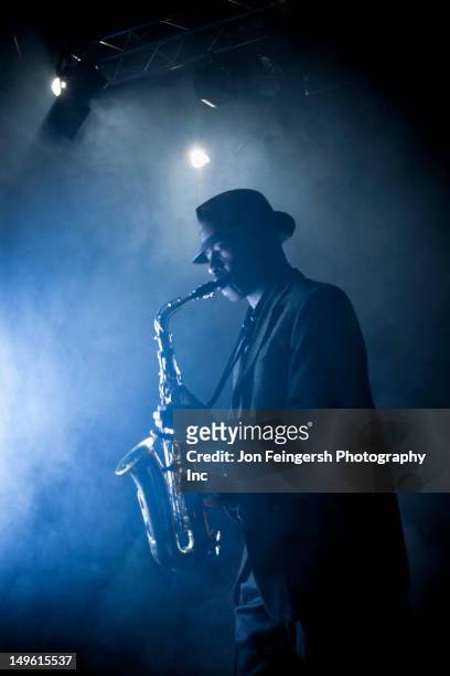 black musician playing saxophone on stage - blues musician stock pictures, royalty-free photos & images