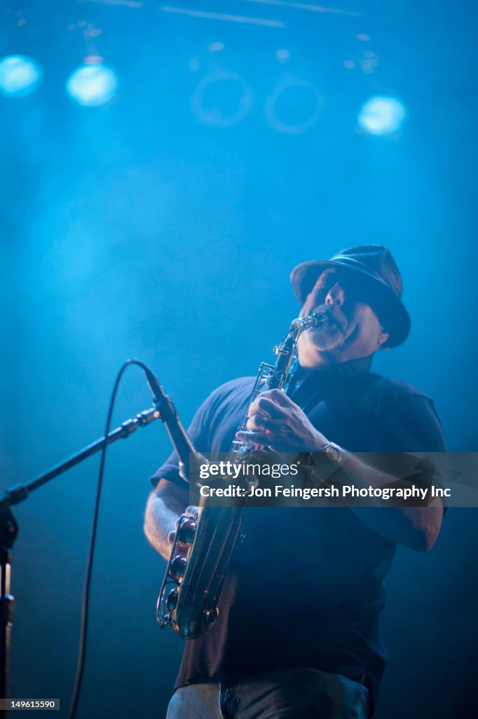 Black musician playing saxophone on stage