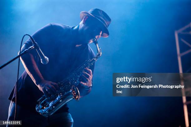 black musician playing saxophone on stage - sassofono foto e immagini stock