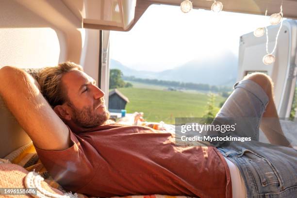 man lying at the back of a van looking at the mountains - fribourg canton stock pictures, royalty-free photos & images