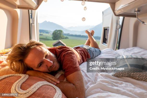 man lying at the back of a van looking at the mountains - fribourg canton stock pictures, royalty-free photos & images