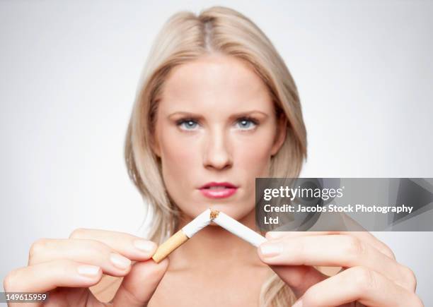 caucasian woman breaking cigarette - breaking habits ストックフォトと画像