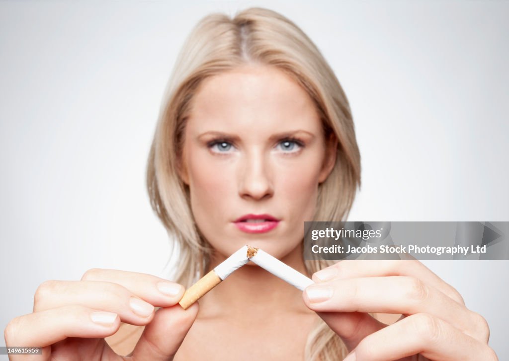 Caucasian woman breaking cigarette