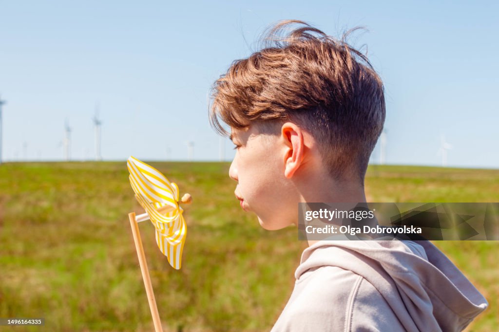Windmill Boy Closeup Of A Teenage Boy Blowing On A Toy Windmill While Standing In ...