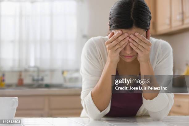 frustrated mixed race woman with head in hands - manos a la cabeza fotografías e imágenes de stock