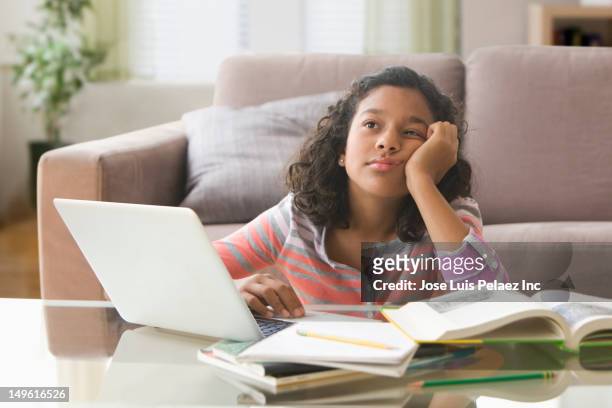 bored hispanic girl doing homework on computer - homework frustration stock pictures, royalty-free photos & images
