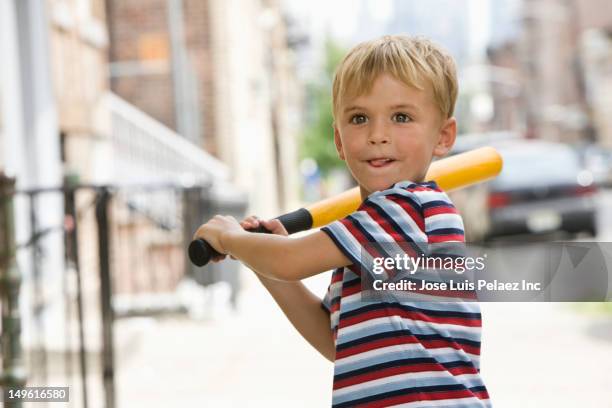 caucasian boy playing baseball on city sidewalk - west new york new jersey stock-fotos und bilder