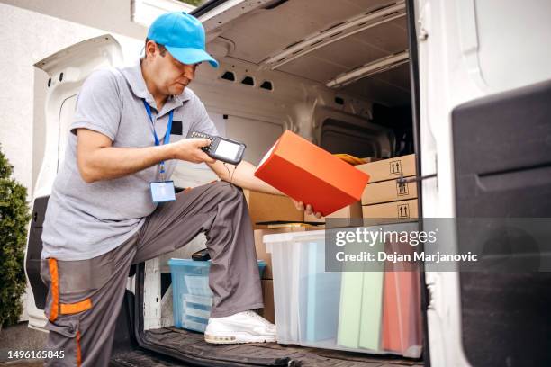 man working in delivery service using scanner before delivery - postbode stockfoto's en -beelden
