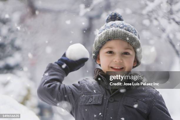 caucasian boy throwing snowball - schneeball stock-fotos und bilder