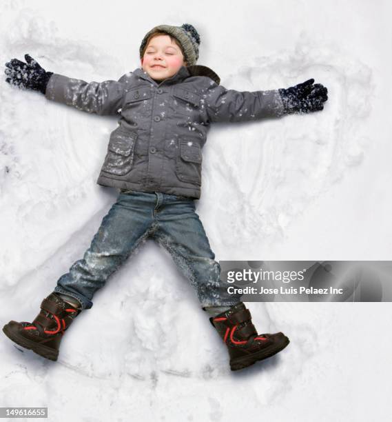caucasian boy making snow angel - snow angel 個照片及圖片檔