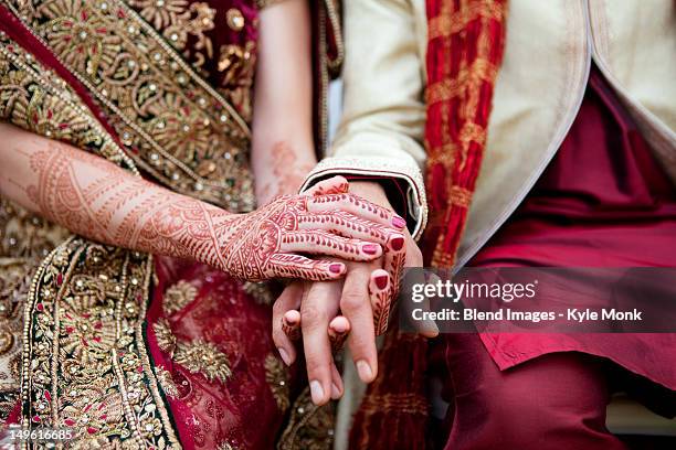 bride and groom in traditional indian wedding clothing with henna tattoos - indian culture stock pictures, royalty-free photos & images