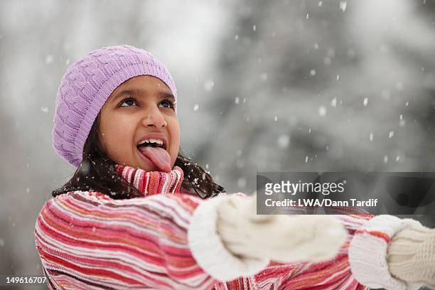 mixed race girl catching snowflakes on her tongue - catching snow stock pictures, royalty-free photos & images