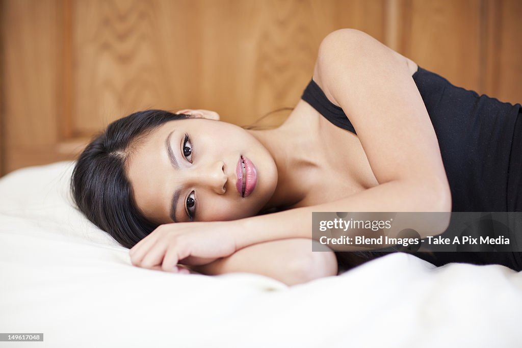 Pacific Islander woman laying on bed