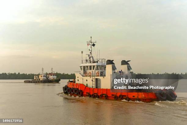 tugboats on the rajang river after sunrise in sibu, sarawak, malaysia - sibu river stock pictures, royalty-free photos & images