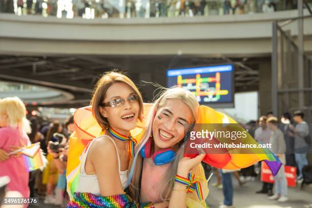 happy asian friend having fun in the street lgbtq pride parade. - light festival parade stock pictures, royalty-free photos & images