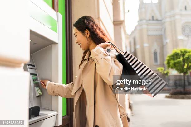 young girl withdrawing money at atm - korean ethnicity stock pictures, royalty-free photos & images