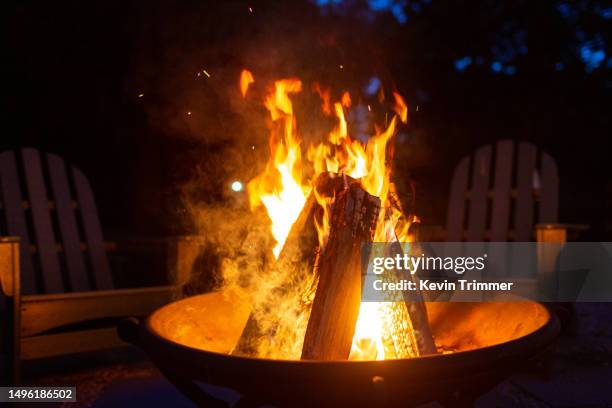 a fire blazes at dusk - cosy fireplace stock pictures, royalty-free photos & images