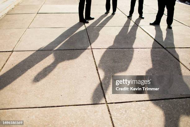 four men and their shadows - long shadow shadow stock pictures, royalty-free photos & images